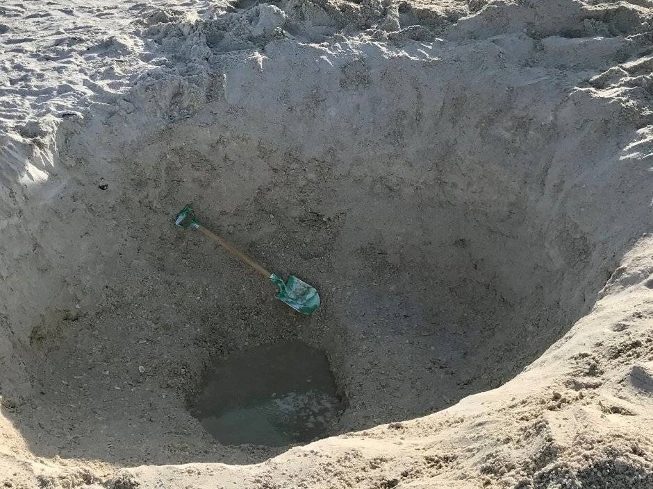 Um Buraco Com Areia Movediça Na Praia Com Uma Cola Baixa Foto de