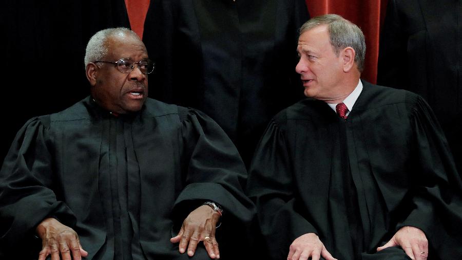 O juiz da Suprema Corte dos EUA Clarence Thomas (à esquerda) conversa com o presidente do tribunal John Roberts (à direita) - 30.nov.2018 - Jim Young/Reuters