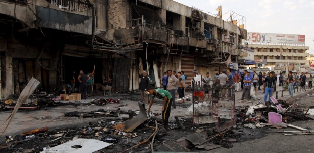 Populares retornam ao local onde um carro-bomba foi detonado em Bagdá, no Iraque, em 21 de julho. O país foi alvo de quatro ataques terroristas com carros-bomba, todos atribuídos ao grupo terrorista Estado Islâmico (EI) - Khalid al-Mousily/Reuters