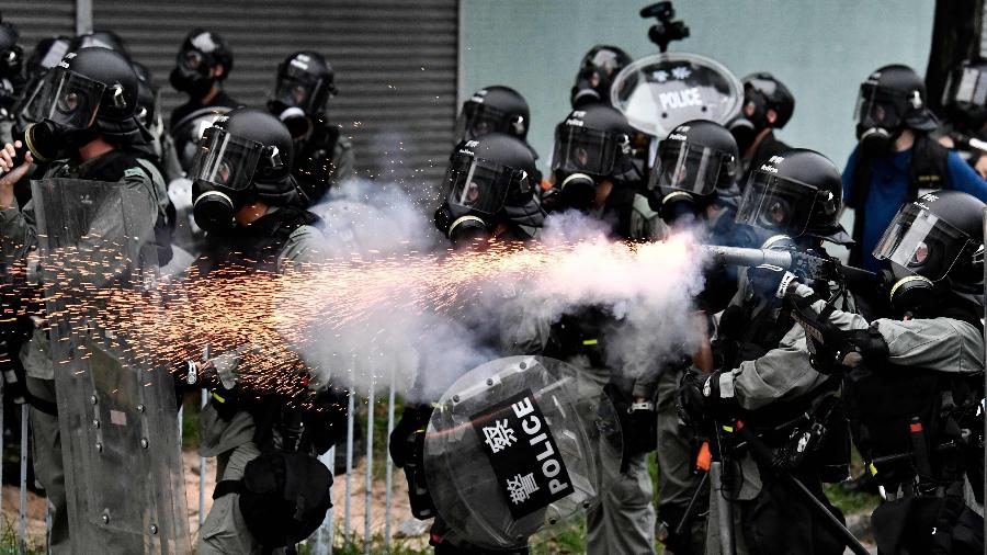 27.jul.2019 - Policial usa gás lacrimogênio para dispersar manifestantes durante protestos no distrito de Yuen Long, em Hong Kong  - Anthony Wallace/ AFP