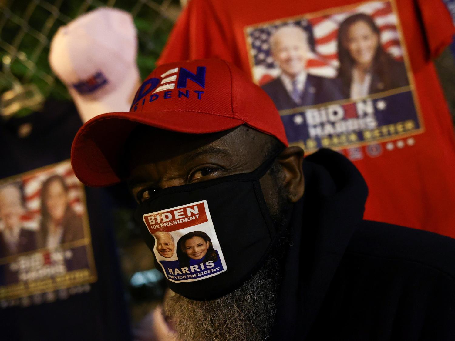 A man wearing a face mask supporting U.S. Democratic presidential nominee Joe Biden looks on as people gather at Black Lives Matter Plaza near the White House during Election Day in Washington, U.S., November 3, 2020. REUTERS/Hannah McKay ORG XMIT: MEX - Hannah McKay/Reuters