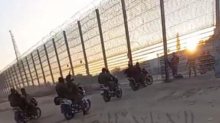 Militantes do Hamas atravessam cerca que foi obstruída para passagem de motos
