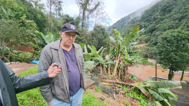 17.mai.2024 - João Pinto observa terreno da casa onde vive, em Caxias do Sul, que está comprometido