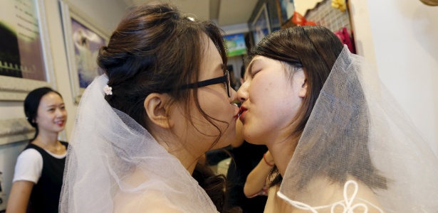 Li Tingting (à dir.) e Teresa se beijam enquanto usam vestidos de noiva em um estúdio de fotografia em Pequim, na China - Kim Kyung-Hoon/Reuters