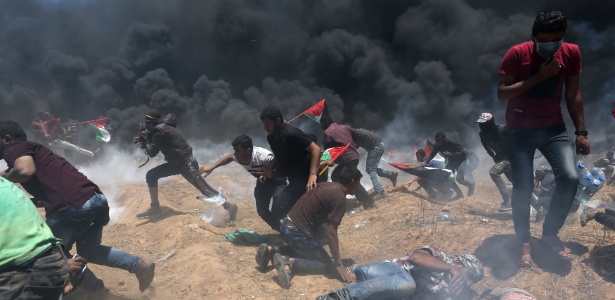 Manifestantes palestinos correm de bombas de gás lançadas por forças israelenses durante protestos contra a inauguração da embaixada dos EUA em Jerusalém - Ibraheem Abu Mustafa/Reuters