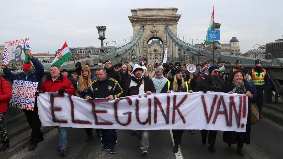 19.jan.2019 - Manifestantes carregam faixa onde se lê "Basta!" enquanto atravessam a ponte mais antiga de Budapeste, na Hungria, durante protesto contra a política de governo do premiê Viktor Orban para a reforma trabalhista - Ferenc Isza/AFP