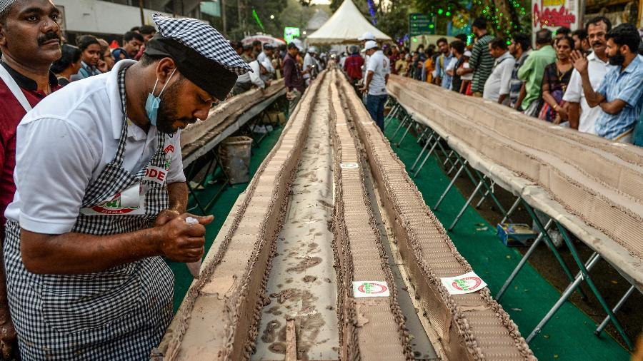 Na Índia, padeiros tentam bater recorde de maior bolo do mundo ao prepararem receita com 6,5 km do doce - Arun Sankar/AFP