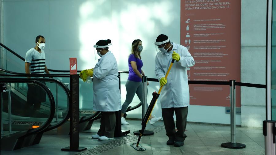 Trabalhadores de limpeza higienizam a entrada do Shopping Leblon, no Rio - ANDRE MELO ANDRADE/ESTADÃO CONTEÚDO