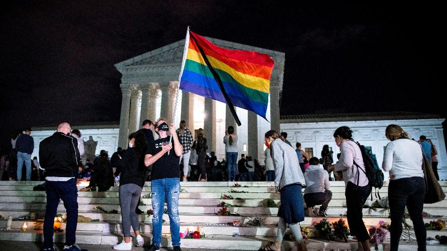 Homem empunha bandeira do arco-íris do lado de fora da Suprema Corte dos EUA, em Washington