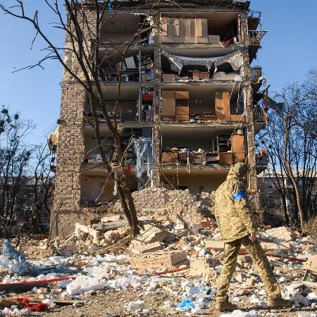 18.mar.2022 - Militar da Ucrânia caminha próximo a prédio danificado por bombardeio - REUTERS/Vladyslav Musiienko