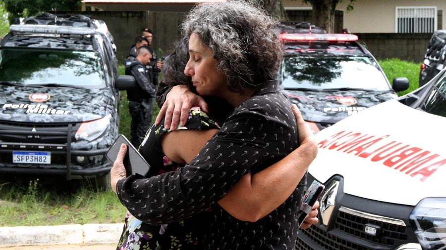 Parentes de alunos se abraçam na entrada da escola Primo Bitti, um dos alvos de ataque a tiro em Aracruz, no Espírito Santo - Kadija Fernandes/AFP