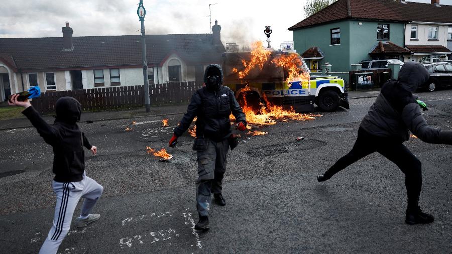 Manifestantes jogam coquetéis molotov contra um carro da polícia após um ato anti-Acordo da Sexta-Feira Santa no 25º aniversário do acordo de paz, em Londonderry, Irlanda do Norte - 10.abr.2023 - Clodagh Kilcoyne/Reuters