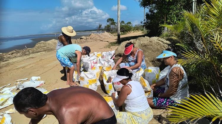 Moradores enchem sacos de areia para amenizar impacto das ondas Moradores enchem sacos de areia para amenizar impacto das ondas