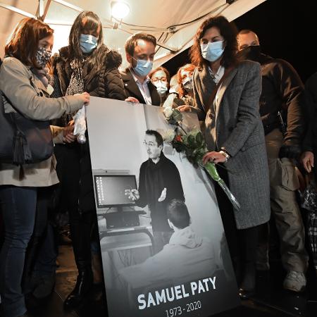20.out.2020 - Parentes e amigos seguram uma foto do professor Samuel Paty em homenagem em Conflans-Sainte-Honorine; ele foi decapitado em um atentado que chocou a França - Bertrand Guay/AFP