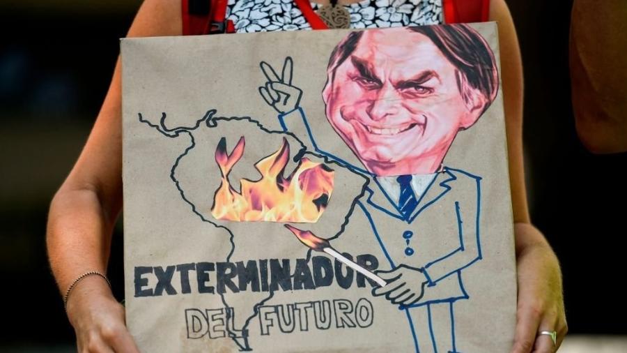 "Exterminador do futuro", diz cartaz que mostra Bolsonaro com um palito de fósforo, incendiando a Amazônia, em agosto de 2019 - Getty Images