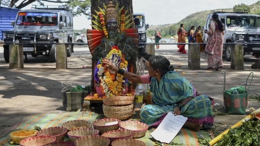 Em foto de setembro de 2022, ex-devadasi coloca coroa de flores em imagem decorada da deusa Yellamma Devi  -  Manjunath Kiran / AFP