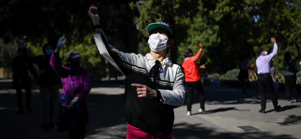 Chineses usam máscaras enquanto se exercitam em um parque de Pequim - Wang Zhao/AFP