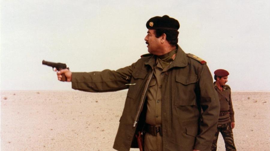 Sadam Hussein testa uma arma em deserto no Iraque, em 2003 - AFP