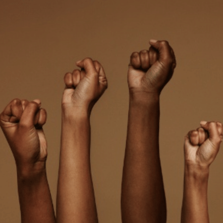 Mãos negras levantadas com punhos fechados em referência ao movimento negro. - Brasil Escola