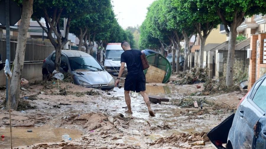 30.out.2024 - Homem caminha por uma rua coberta de lama em uma área inundada em Picanya, perto de Valência, leste da Espanha