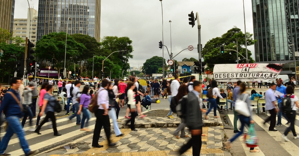 30.nov.2015 - Estudantes bloqueiam, com cadeiras e cartazes, um dos sentidos da Avenida Brigadeiro Faria Lima, em protesto contra a reorganização escolar no estado de São Paulo