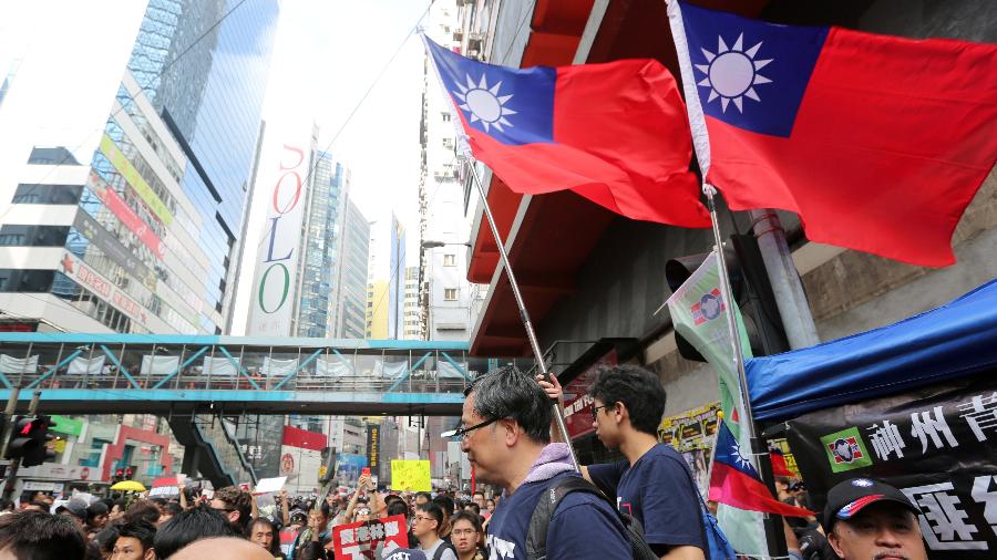 16.jun.2019 - Manifestantes seguram a bandeira de Taiwan durante protestos a favor de Hong Kong - James Pomfret/Reuters