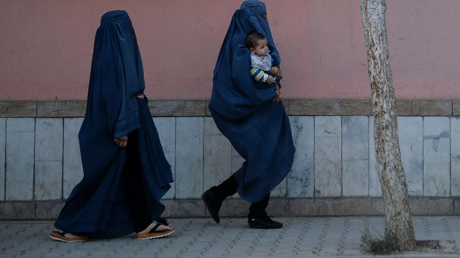 22.out.21 - Mulheres afegãs vestidas de burca caminham ao longo de uma trilha em Cabul - HOSHANG HASHIMI/AFP