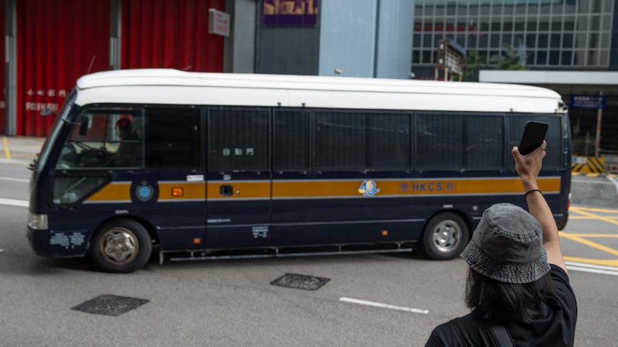 10.set.2022 - Defensor de movimento pró-democracia acena para uma van onde estavam grupo condenado à prisão por publicar livros infantis que supostamente tentem explicar o movimento democrático, em Hong Kong - Bertha Wang/AFP