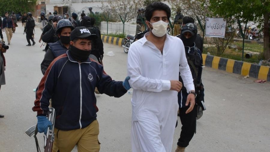 6.abr.2020 - Policial prende médico durante protesto em Quetta por falta de equipamentos de segurança para trabalhar. O governo do Paquistão impôs quarentena nacional como prevenção às infecções pelo novo coronavírus - Banaras Khan/AFP