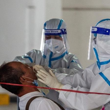 19.jul.2020 - Pessoas passam por teste do novo coronavírus em Hong Kong - Isaac Lawrence/AFP