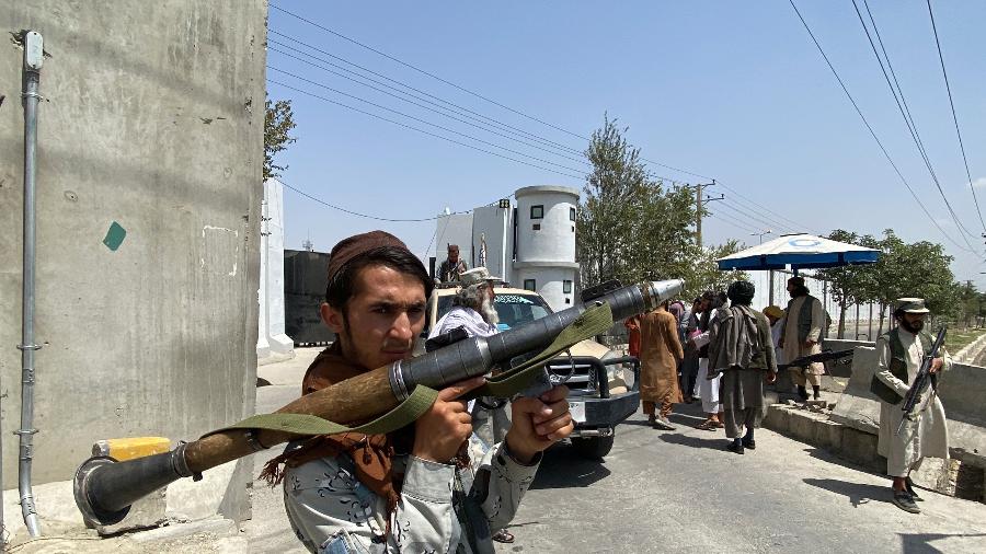 17.ago.2021 - Taleban segura lançador de granadas enquanto fica de guarda em um portão de entrada do lado de fora do Ministério do Interior em Cabul - Javed Tanveer/AFP