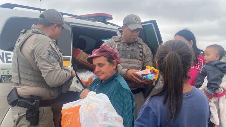 PMs entregam doações no acostamento da BR-290 a moradores da Ilha das Flores, em Porto Alegre