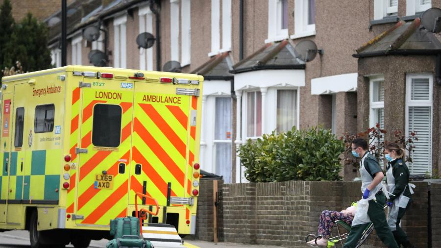 Paramédicos usando máscaras contra coronavírus levam paciente para ambulância em Londres - Hannah McKay/Reuters