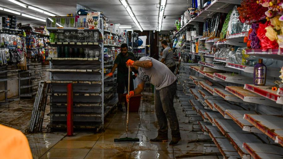 Funcionários de mercado limpam lama que invadiu estabelecimento em Petrópolis após temporal na cidade serrana - Alexandre Neto/Photopress/Estadão Conteúdo