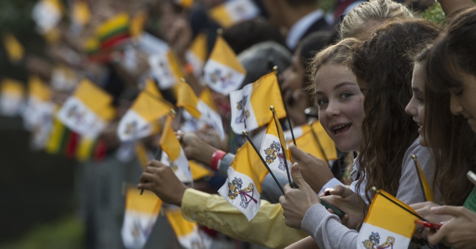 23.set.2015 - Crianças esperam pela chegada do papa Francisco na região do National Mall, em Washington, nos Estados Unidos, balançando bandeirinhas com o símbolo do Vaticano