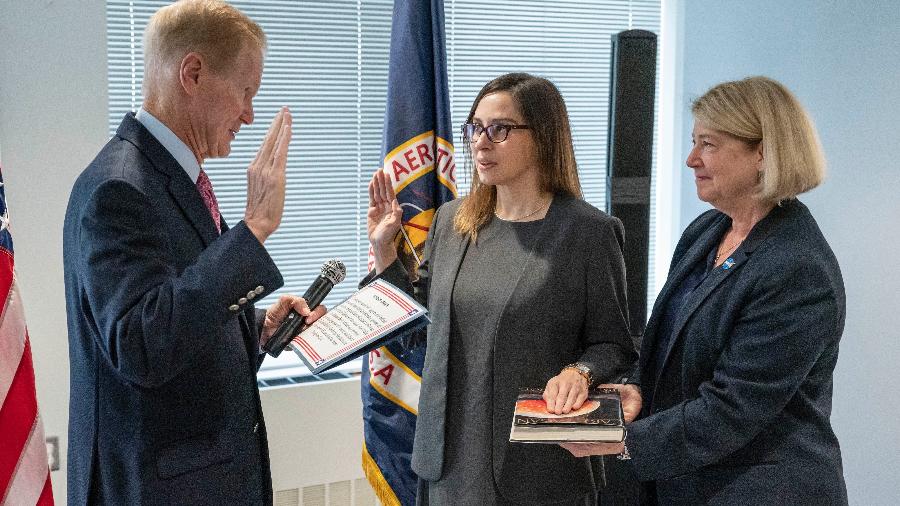 Makenzie Lystrup fazendo seu juramento com a mão em uma cópia do best-seller "Pale Blue Dot"  - Divulgação/ Nasa Goddard