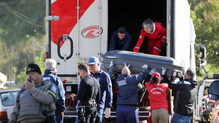 Trabalhadores forenses carregam corpos de vítimas em caminhão refrigerado na cidade de Muçum, no Rio Grande do Sul, após ciclone extratropical 