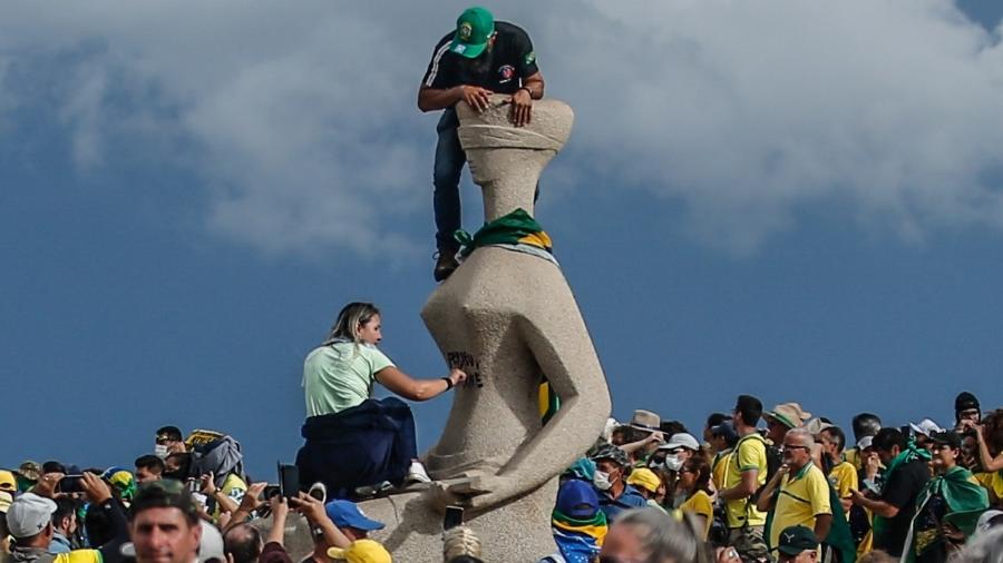 12> BRASÍLIA, DF, BRASIL, 08.01.2023 Golpista picha a estátua da Justiça, na praça dos Três Poderes, com a frase ?perdeu,mané'. Ela foi presa em operação da Polícia Federal.