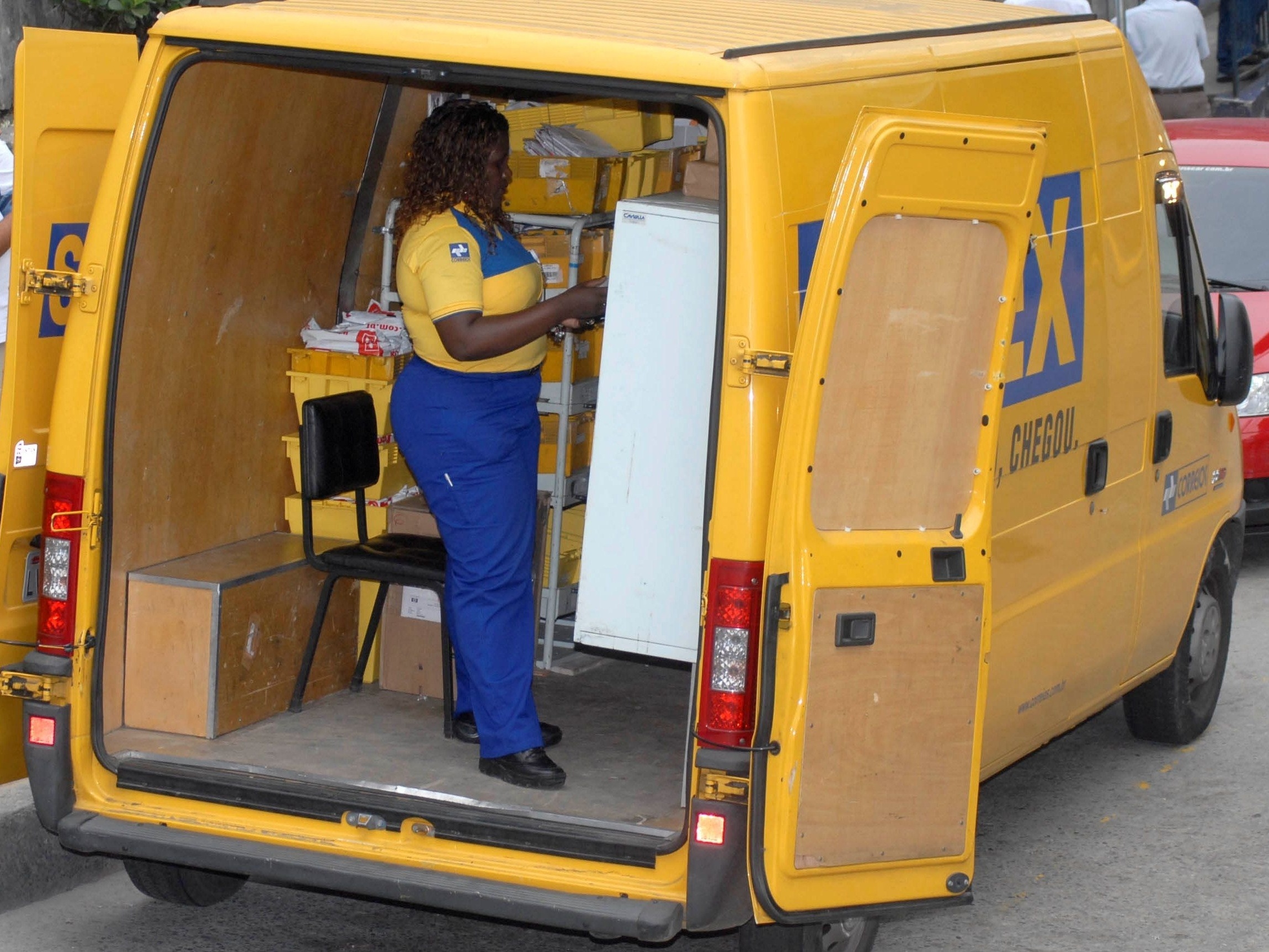 Caminhões e veículos dos Correios utilizam calçada como