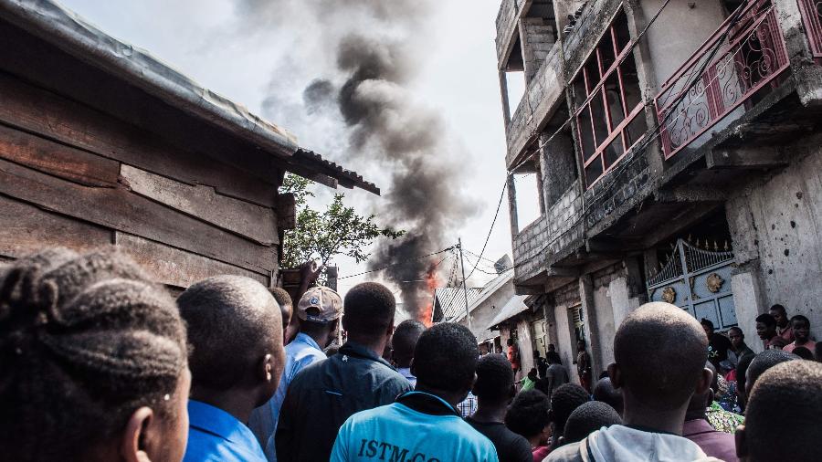Pessoas observam fumaça de acidente aéreo em Goma, na República Democrática do Congo - Pamela Tulizo/AFP