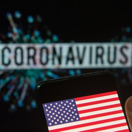 Bandeira dos Estados Unidos (EUA) em frente ao nome do coronavírus - Budrul Chukrut/SOPA Images/LightRocket via Getty Images