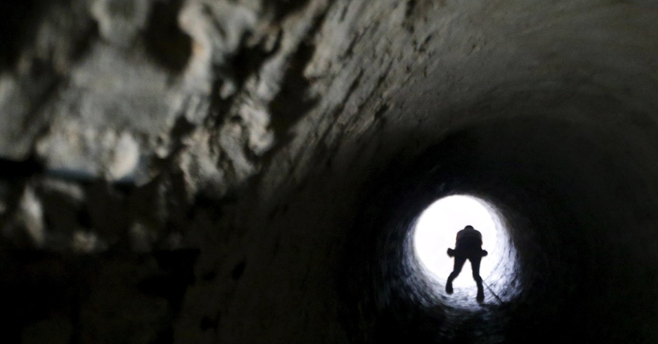 4.nov.2015 - Palestino sobe em uma corda para sair de um túnel de contrabando, que foi inundado pelas forças de segurança egípcias, na fronteira entre o Egito e a faixa de Gaza