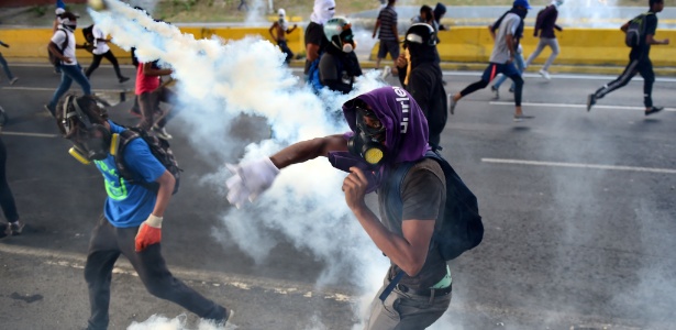 Opositores venezuelanos em confronto com a polícia durante protesto contra o presidente Nicolas Maduro em Caracas - Ronaldo Schemidt/AFP