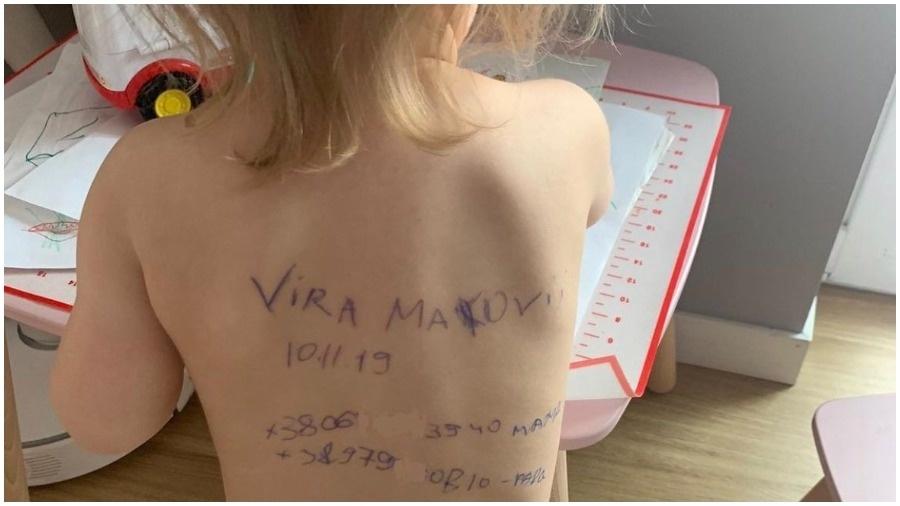 Temendo a morte em meio à guerra, a mãe de uma criança ucraniana escreveu contato nas costas da filha - Reprodução: Twitter