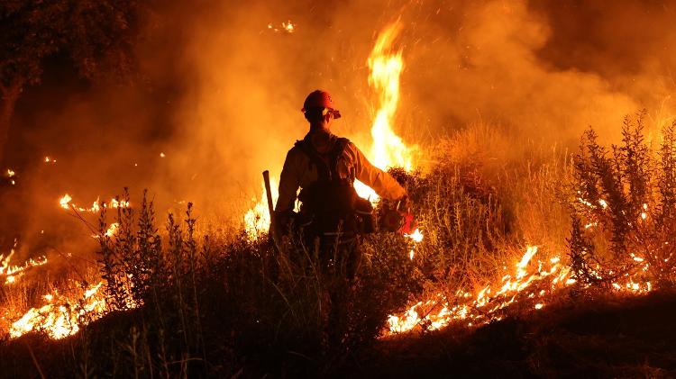 Bombeiro tenta controlar incêndio em Riverside County, Califórnia, no sábado (15)