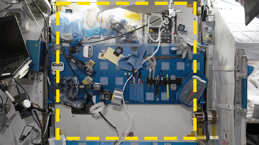 Marcada com adesivos amarelos, uma das áreas da ISS que serviram como “poços de teste” na “escavação” realizada na estação espacial: pensada para ser uma bancada de manutenção, ela é mais usada como local para guardar ferramentas e outros objetos - NASA/International Space Station Archaeological Project, CC BY