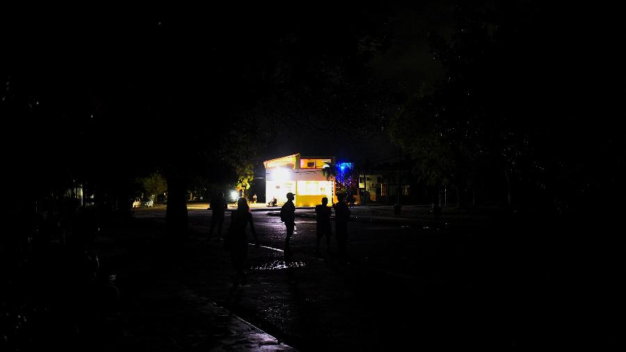 13.mai.2025 - Pessoas caminham em rua escura durante apagão em Havana 13.mai.2025 - Pessoas caminham em rua escura durante apagão em Havana