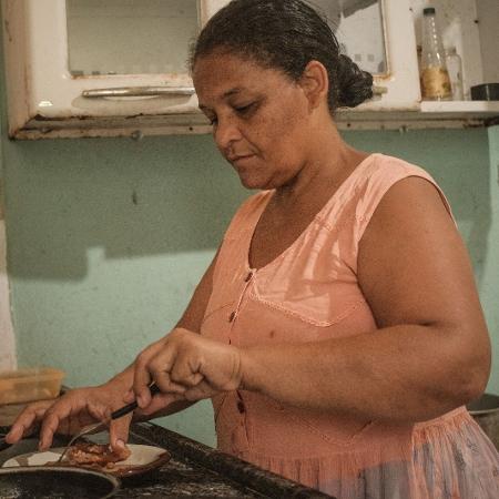 Conceição preparando o almoço na cozinha da horta comunitária da ocupação 15 de novembro, em Paulista (PE)