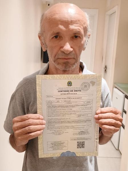 Antônio Mota da Silva mostra certidão de óbito de 2017 com seu nome