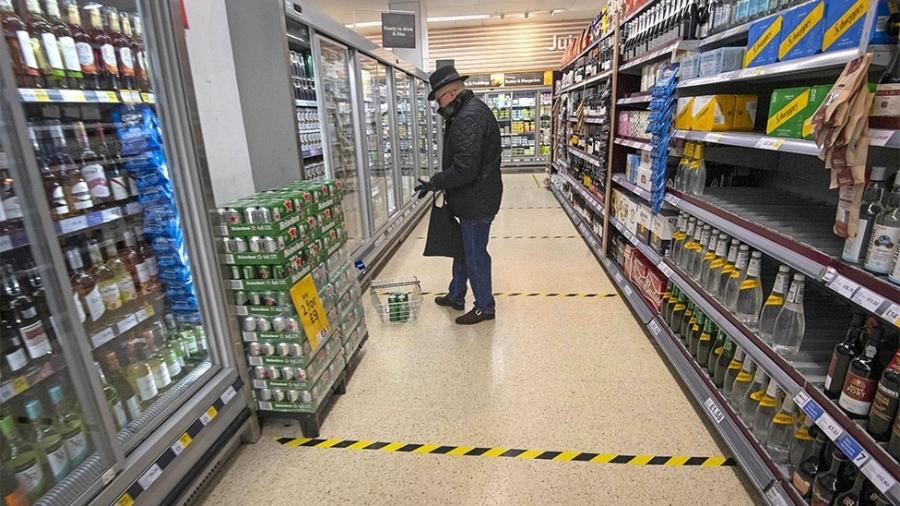 Linhas no chão marcam o distanciamento social em um supermercado - Getty Images